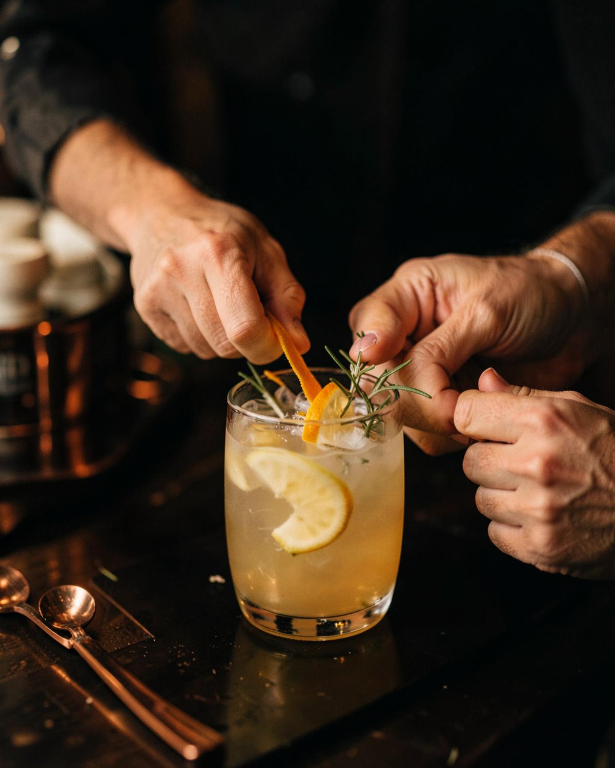 Hands garnishing a specialty non-alcoholic drink